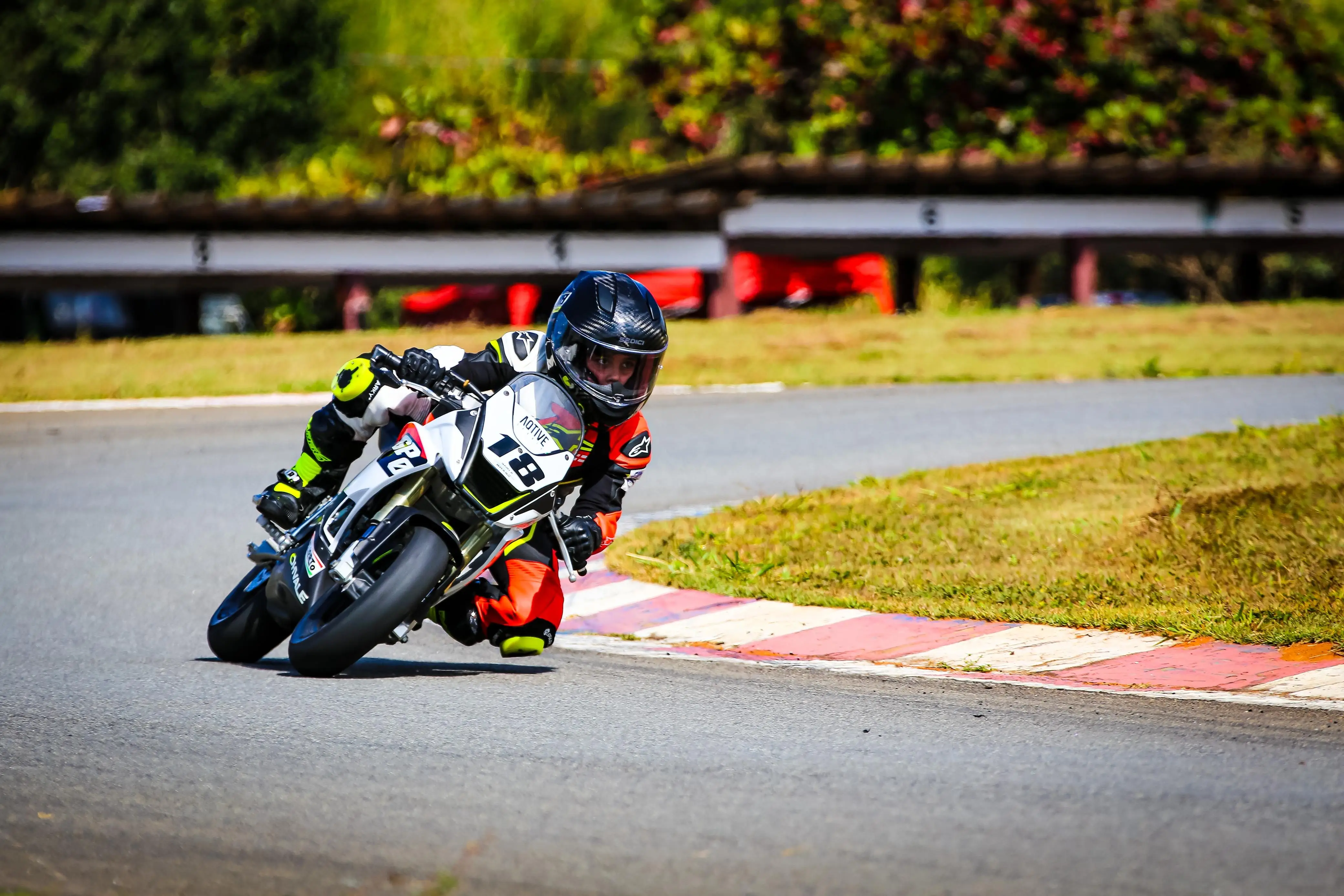 A young road-racer cornering knee-down on a mini GP bike.
